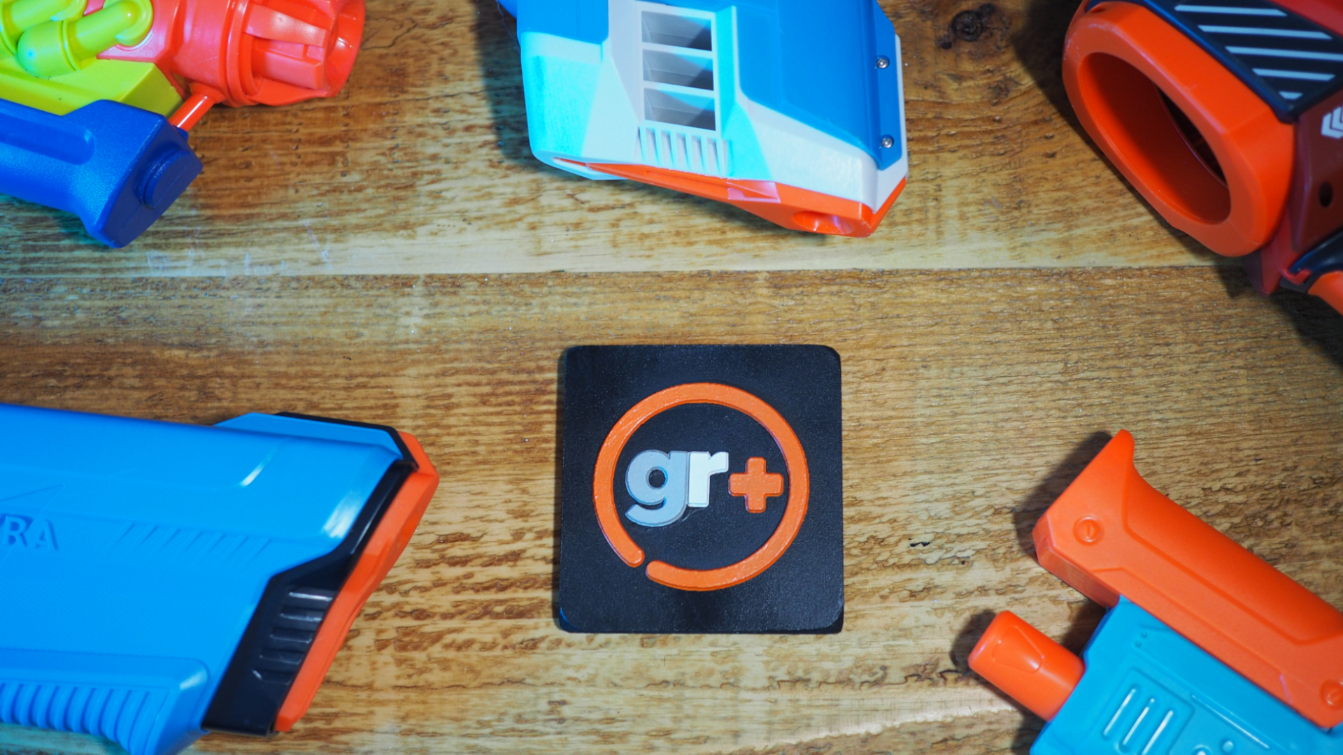 A selection of water guns surrounding a GamesRadar+ logo on a wooden surface