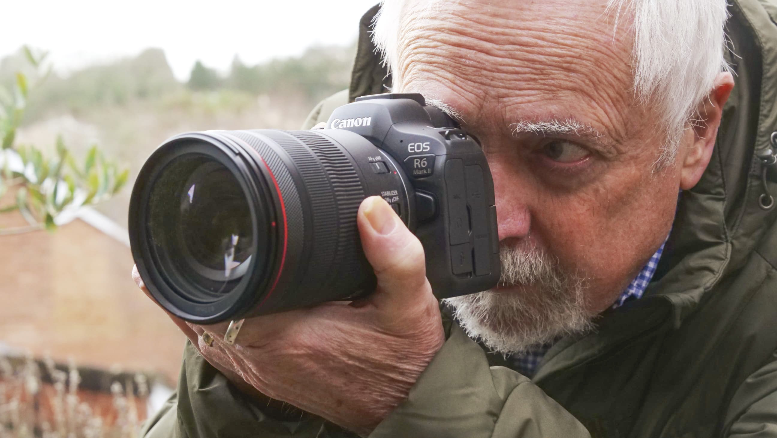 Reviewer taking a picture with Canon EOS R6 II looking through the viewfinder