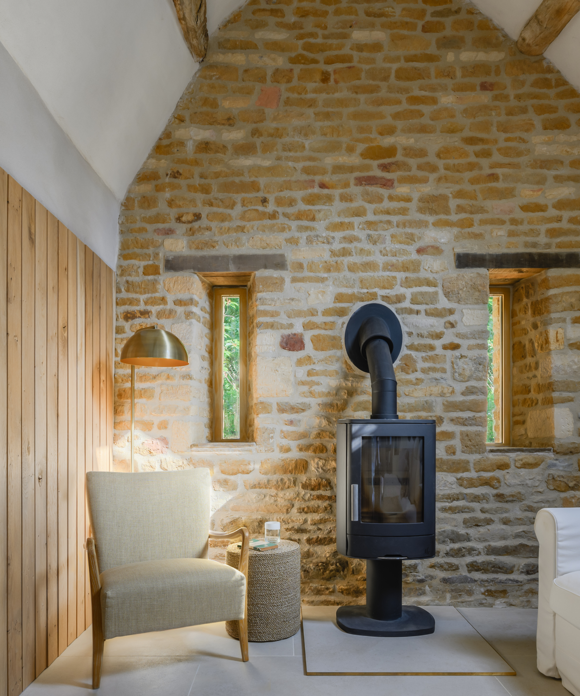 inside of a barn conversion with slit windows either side of log burner
