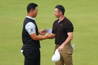 Tom Kim and Rory McIlroy shake hands on the 18th green