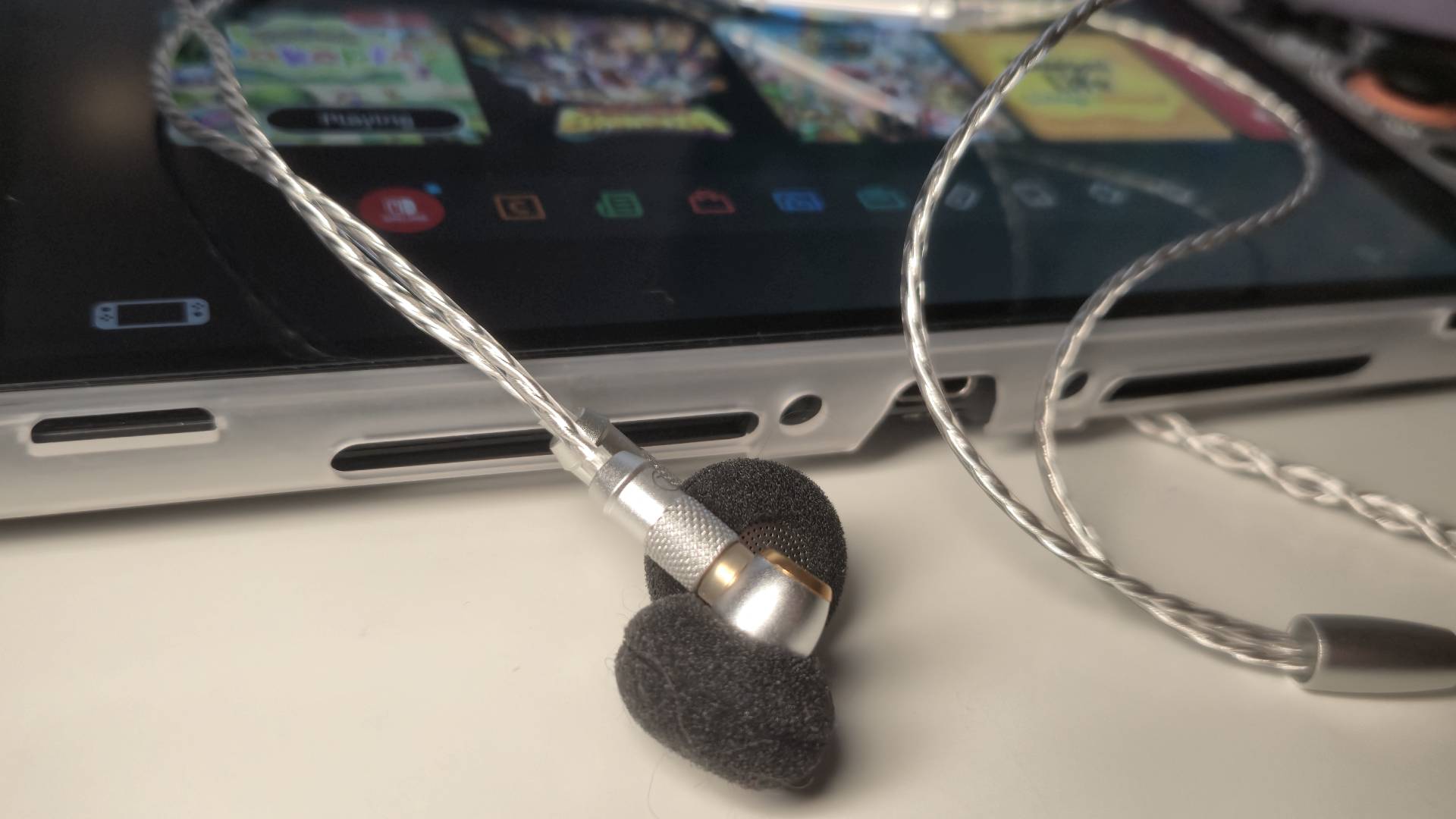 Photo of the SIVGA M260 wired earbuds sitting below a Switch 2.