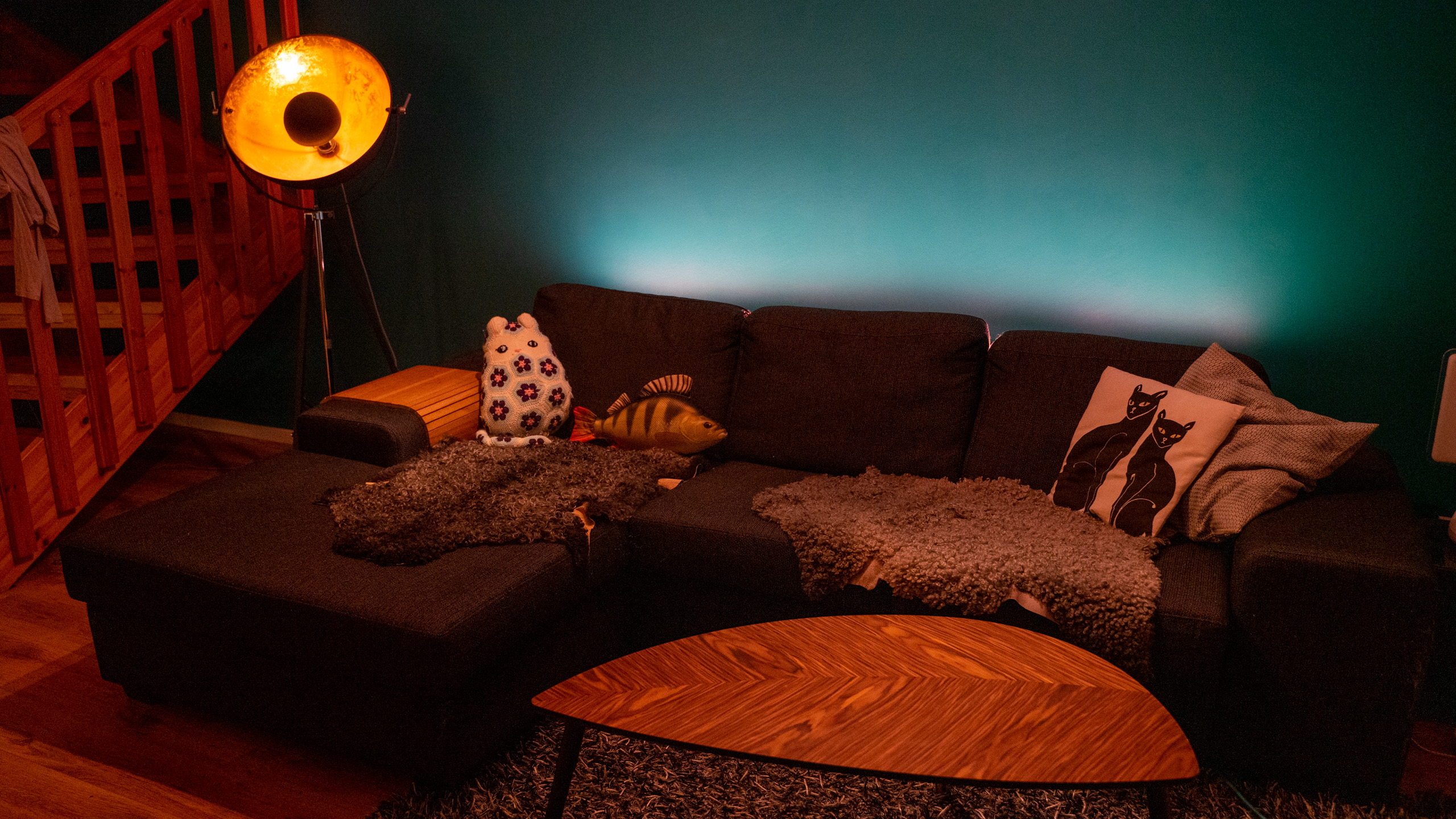 Nanoleaf Essentials Lightstrip lyser upp väggen bakom soffa.