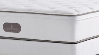 A close-up showing the end of a Four Seasons Signature Mattress, including the Four Seasons label and the quilted top