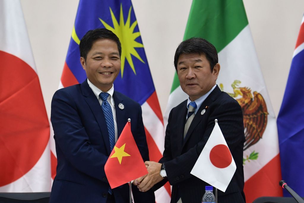 Vietnam&amp;#039;s Trade Minister Tran Tuan Anh (L) shakes hands with Japan&amp;#039;s Economic Revitalization Minister Toshimitsu Motegi (R) at the end of a Trans Pacific Partnership (TPP) press conference