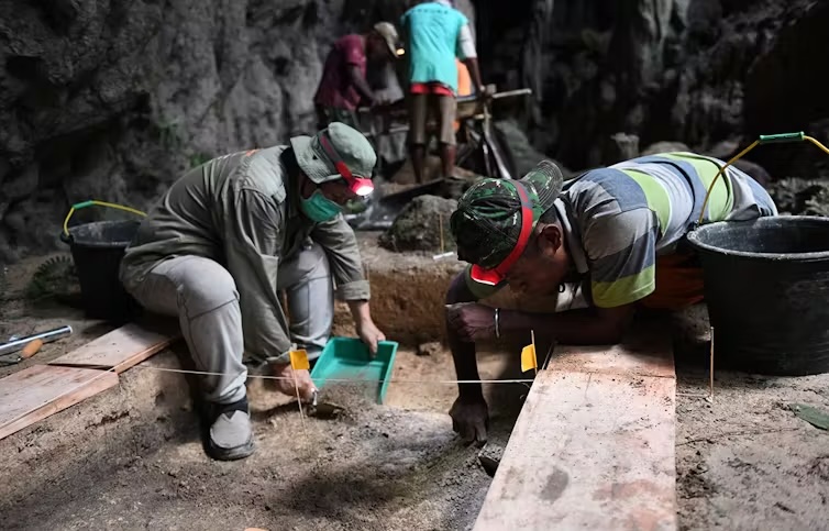 Men excavate inside a cave