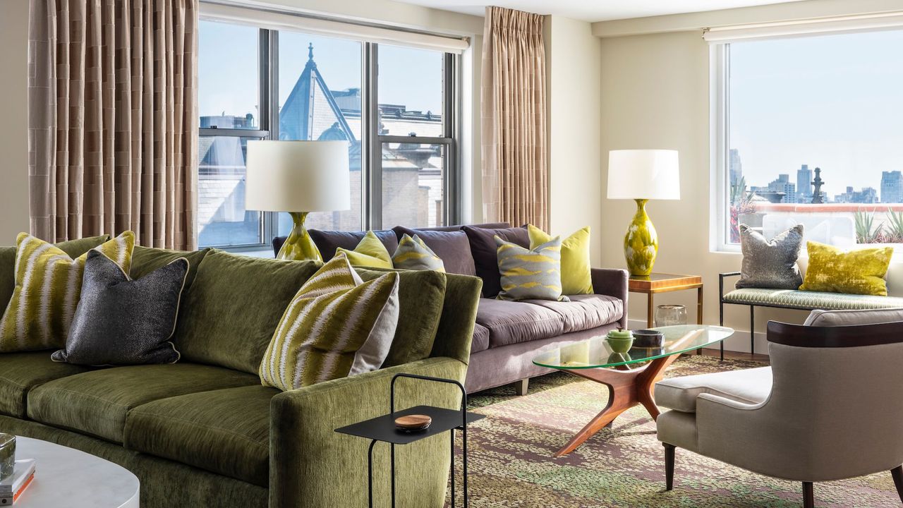 living room with green sofa, green cushions, green lamp, and green patterned rug