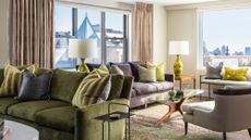 living room with green sofa, green cushions, green lamp, and green patterned rug