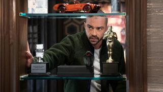 Jesse Williams looking through a shelf in Ben's apartment in Only Murders in the Building.