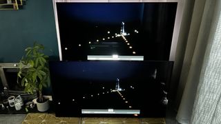 Two Philips OLED TVs next to each other, with the same image on-screen, showing differences in the brightness and color