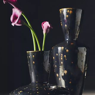 Pink flowers in the Lunar Black Ceramic Vase against a black background.