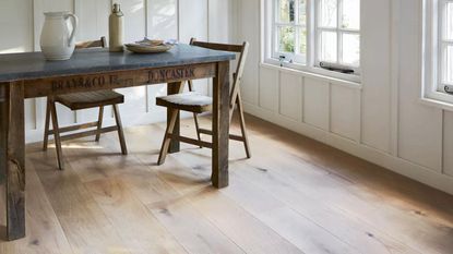 A light hardwood floor with a dining table and chair 