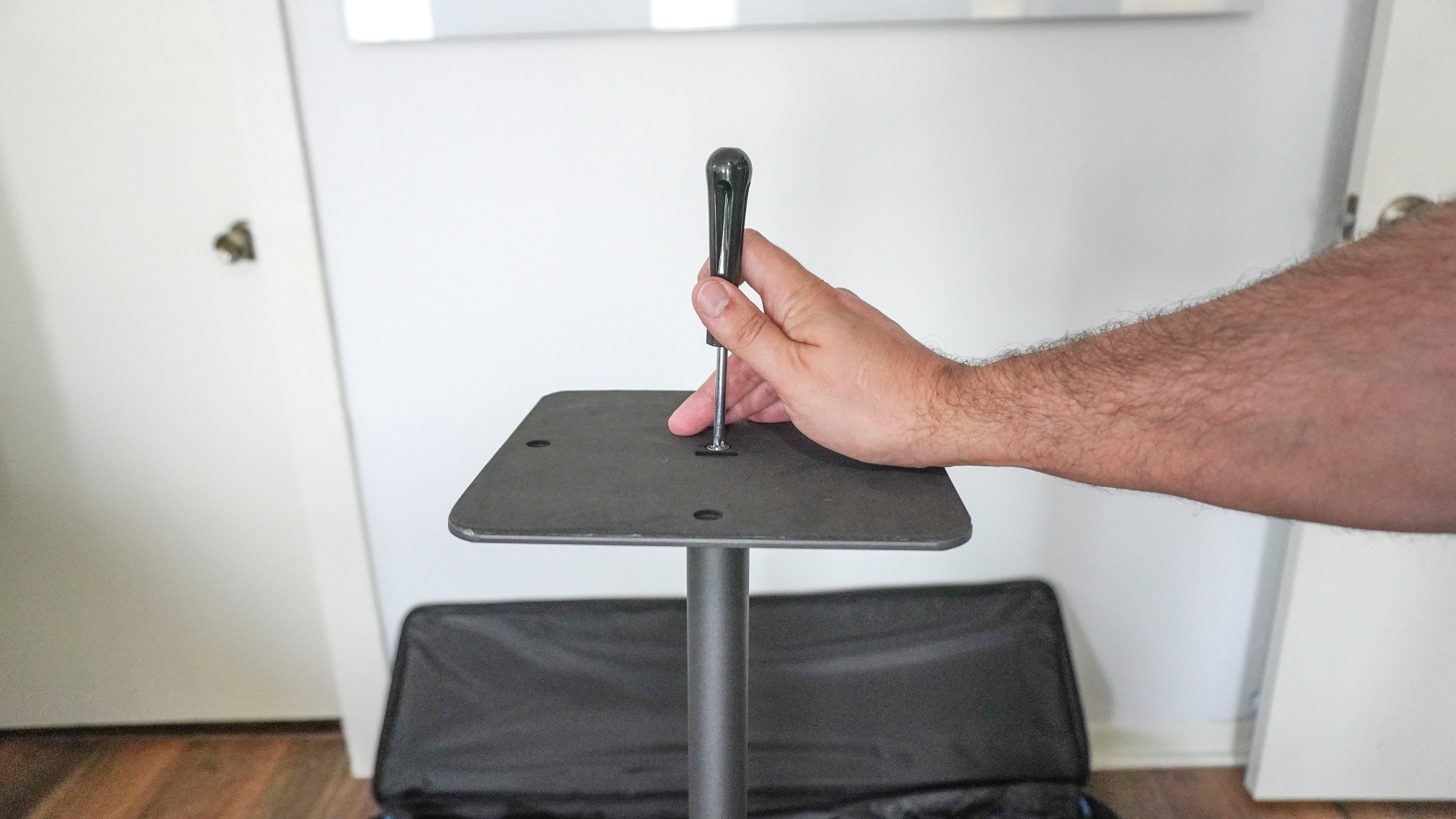 A person installing the metal base on the bottom of the poles that make up the Govee Lightwall's frame