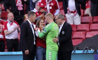 Kasper Schmeichel speaks to Christian Eriksen's wife Sabrina Kvist by the side of the pitch