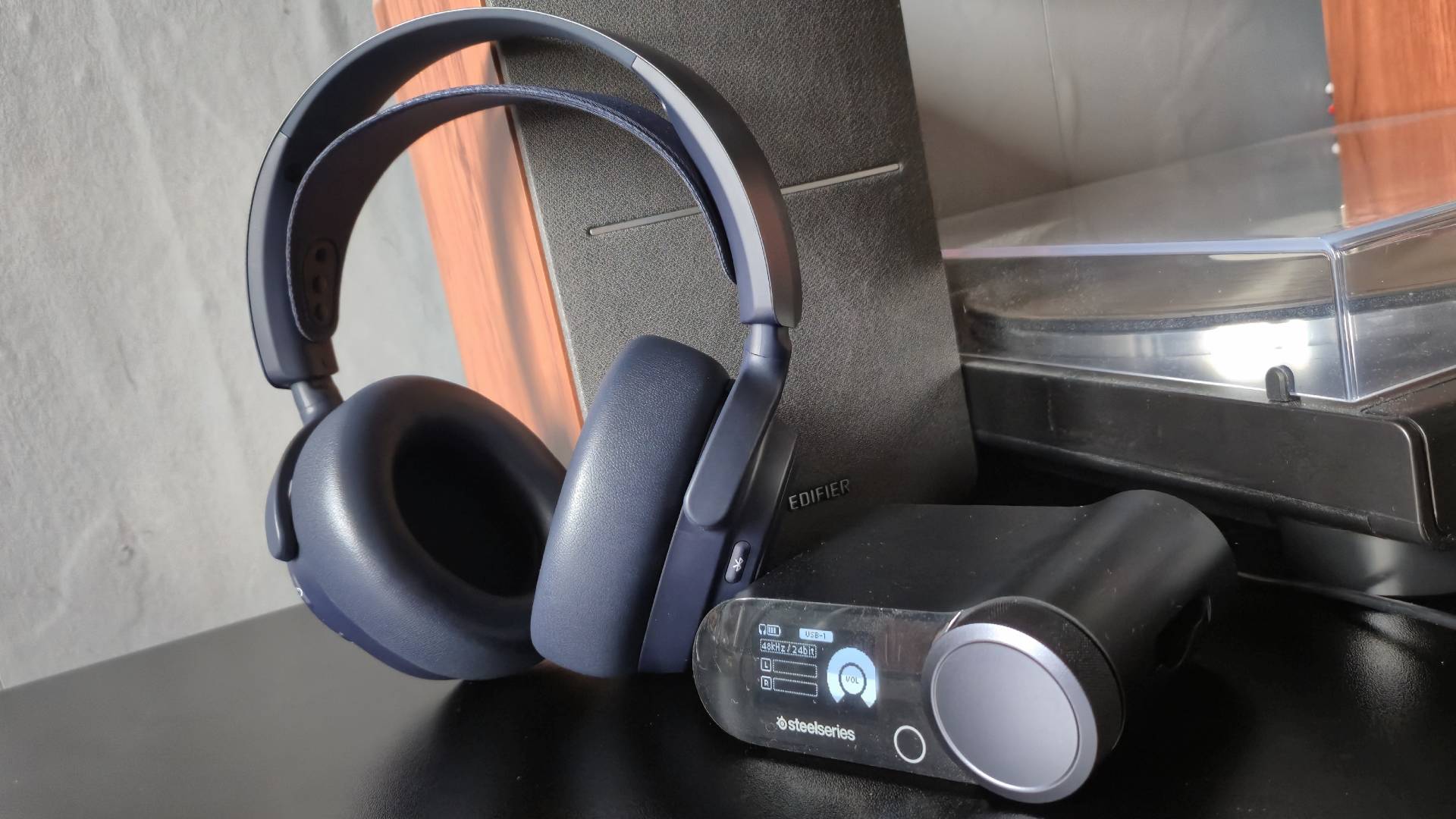 Photo of the SteelSeries Arctis Nova Pro Omni headset sitting next to the Game Hub.
