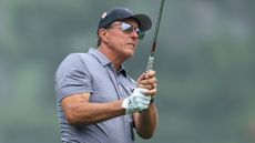 Phil Mickelson hits an iron shot during a Masters practice round