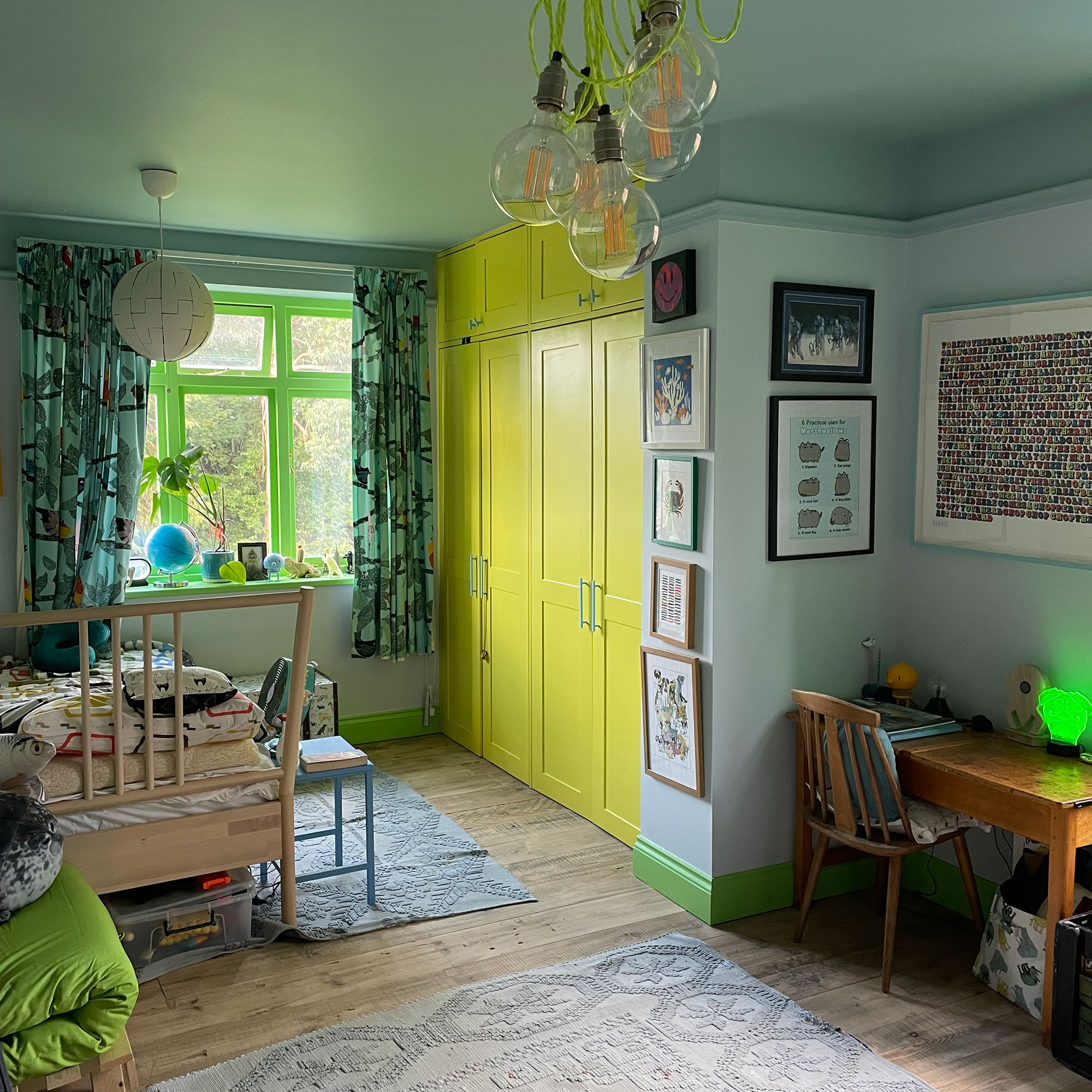 Boys bedroom decorated with green wardrobe doors, skirting boards and window frames