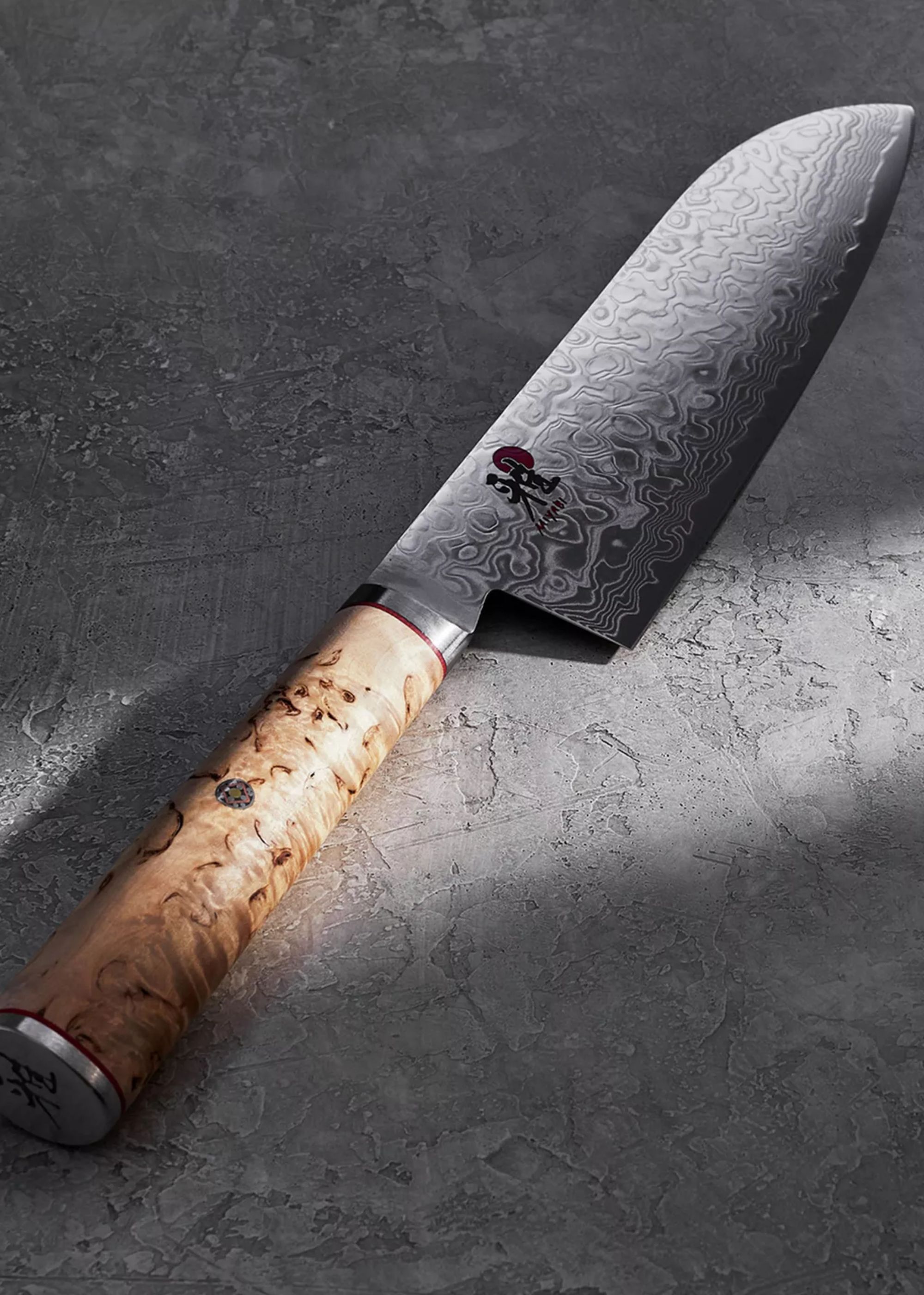 A close up of a textured Japanese knife with a wood handle