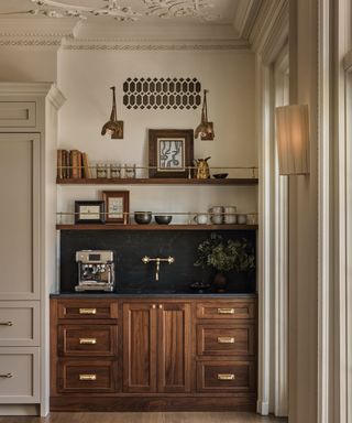 kitchen with heritage plaster details and wooden cabinetry and dark splashback and white walls