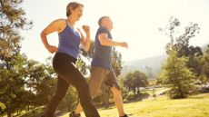 Man and woman walking briskly in park