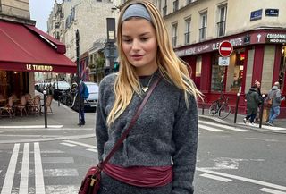 @sabinasocol wearing a gray cardigan with a red sweater underneath in Paris.