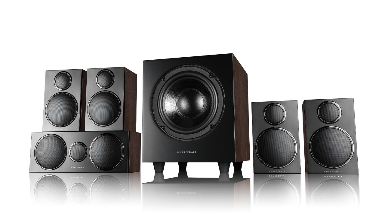 Image shows the Wharfedale DX-3 HCP, which is made up of three rectangular speakers piled up on the left hand side, two next to each other on the right, and a square subwoofer in the middle. They are all black on a white background.