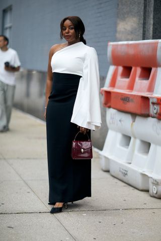 woman wearing black and white dress, black heels, and burgundy bag