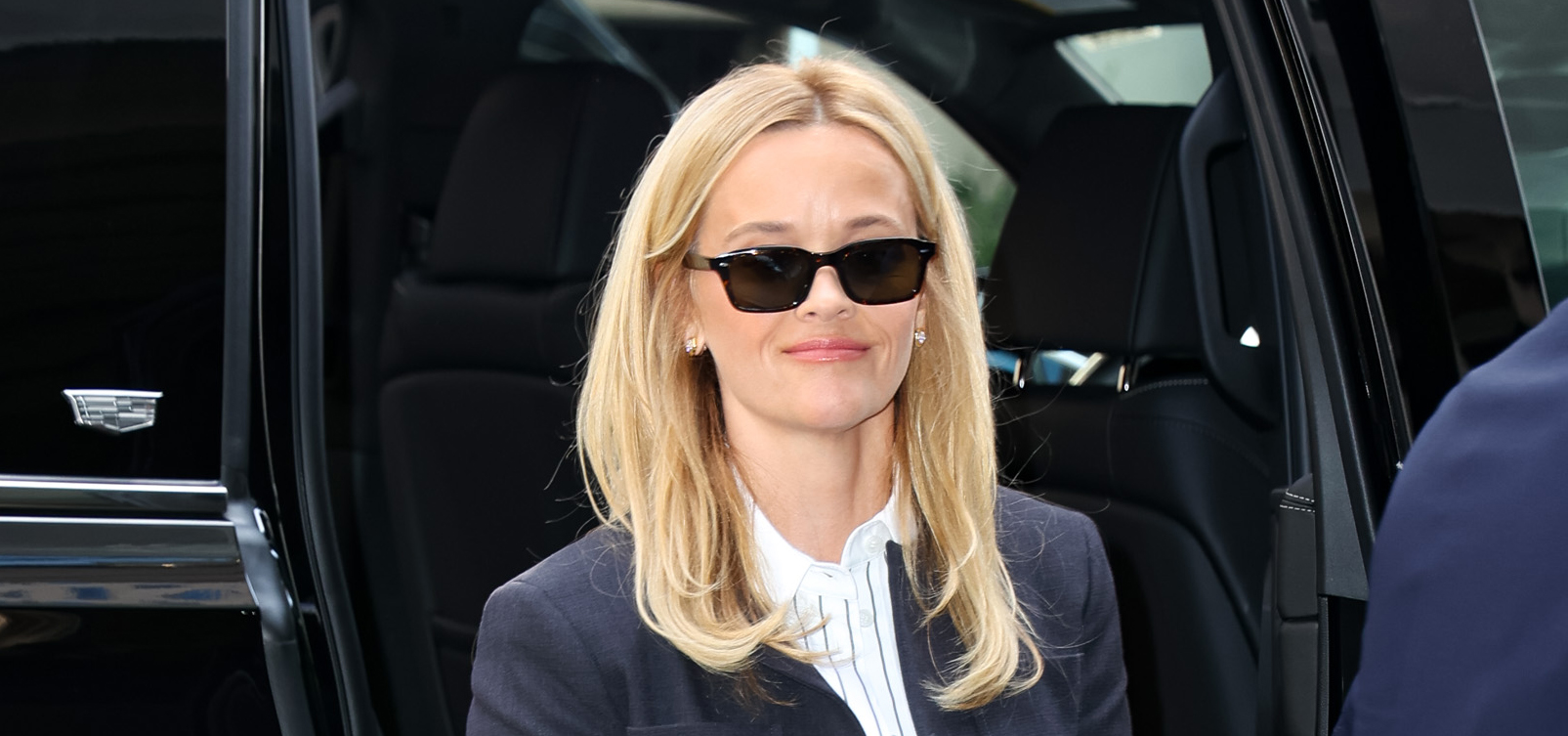 Reese Witherspoon wearing a navy blue skirt suit