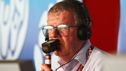 John Motson with a mic at his mouth 