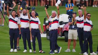 Members of the US Ryder Cup team raise their caps to Patrick Cantlay after his winning putt in the Saturday afternoon fourball at Marco Simone