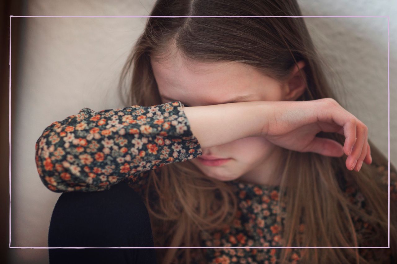 Little girl scared to go to school, covering her face