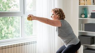 A woman squats at home