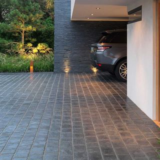 Basalt paving stones on a driveway with a parked grey car