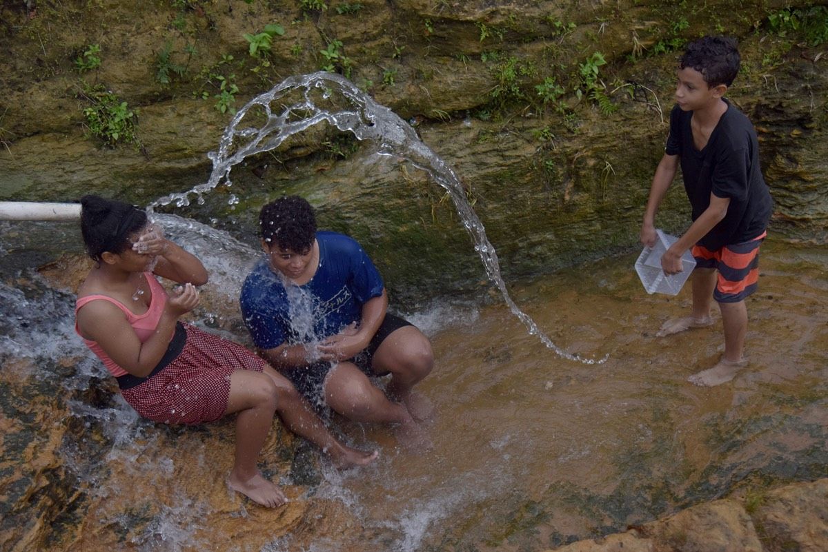 People take a bath in a canal following Hurricane Maria, in Toa Alta, Puerto Rico, on Oct.1, 2017. Less than half of Puerto Ricans have clean drinking water.