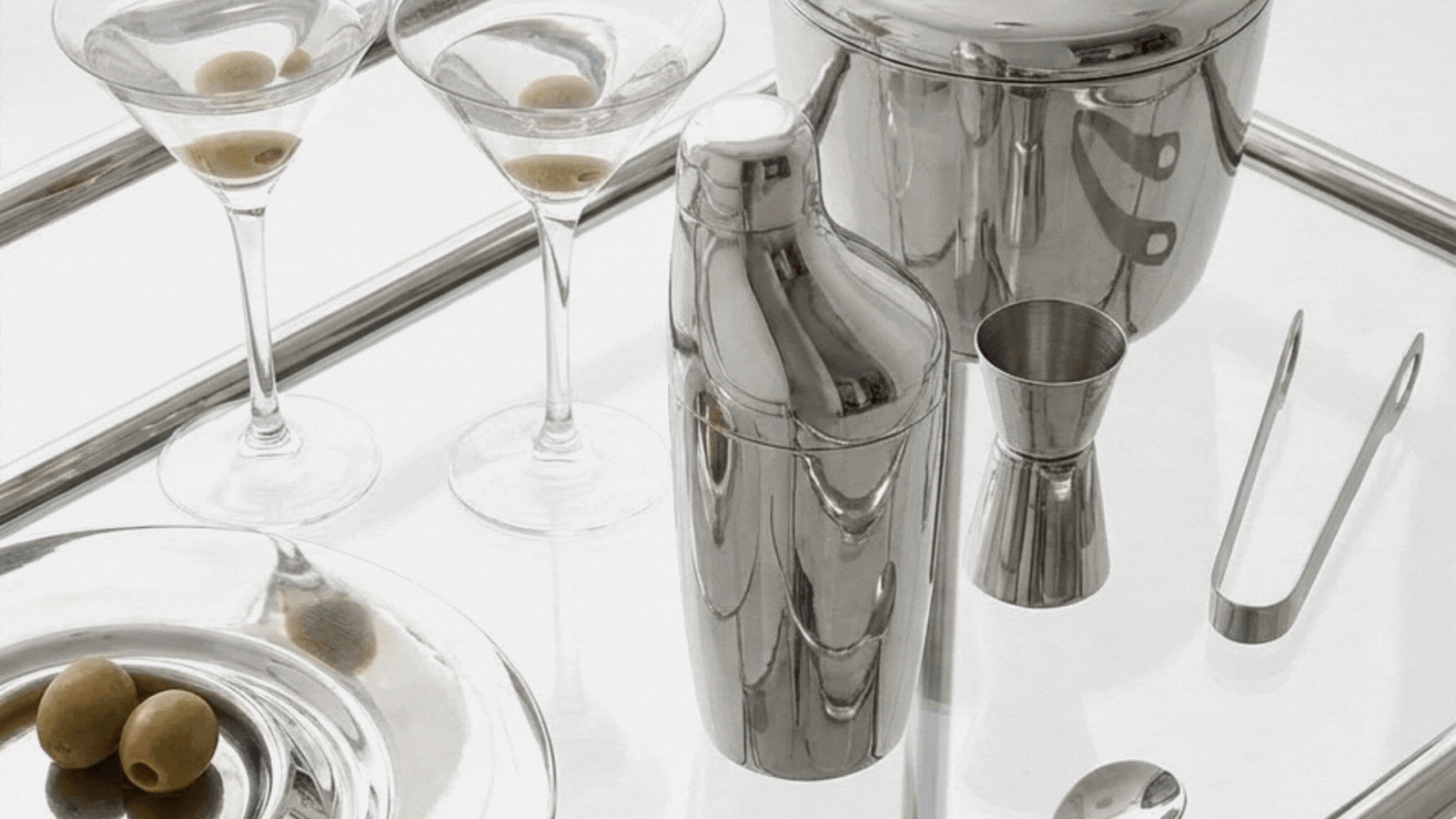 a gif of images of homewares including chrome barware from George Jensen, glassware filled with a pink drink from Fable, shelves styled with ceramics and books and artwork from Paper Collective, a close up of shelves with glass coupes with bows on the stems from Anthropologie, and a bath mat from H&M with a tiger motif