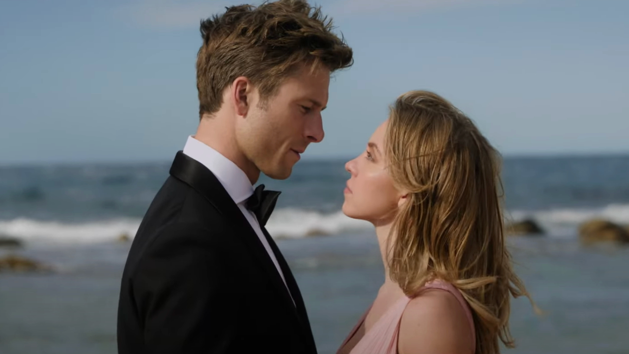 Glen Powell and Sydney Sweeney stare each other down in front of the ocean in Anyone But You.