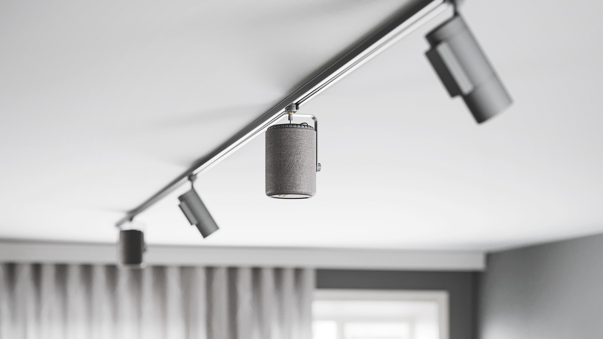An Audio Pro A10 MkII W speaker mounted on a lighting rail on a white ceiling