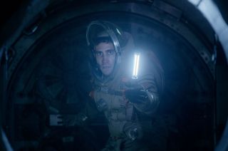 David Jordan (Jake Gyllenhaal) holds up an "oxygen candle" to lure Calvin out of hiding, as seen in "LIFE."
