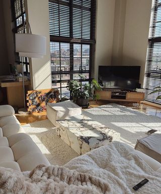 A white living room with a couch, table, and rug