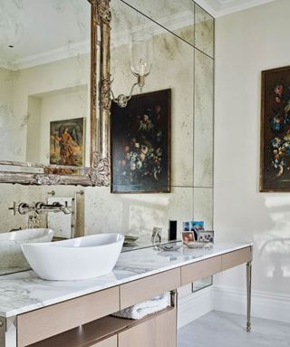 A small bathroom with an antique mirrored wall