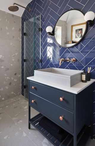 small bathroom with dark blue tiles and countertop basin