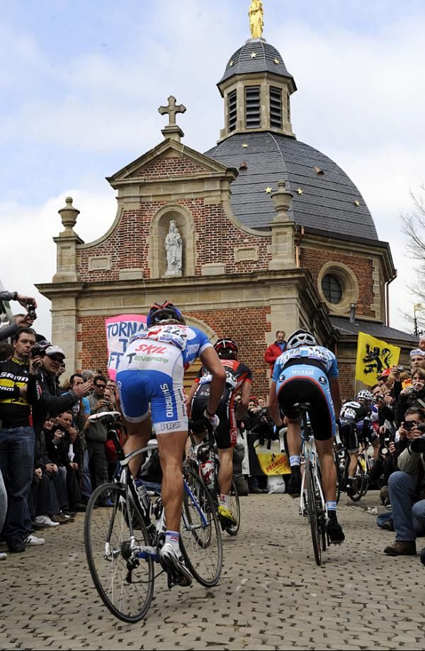 Riders pass the chapel atop the Kapelmuur.