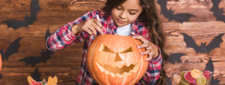 Young girl carving a pumpkin