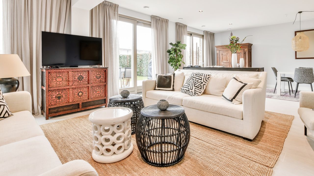 Small living room DIY projects can add character like this neutral living room with boho decor, geometric patterns, white and black coffee tables and textured TV cabinet