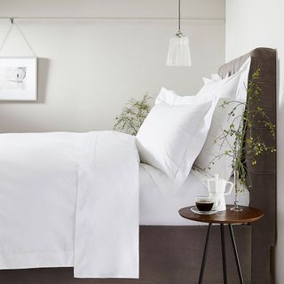 white bedroom with beddings and side table
