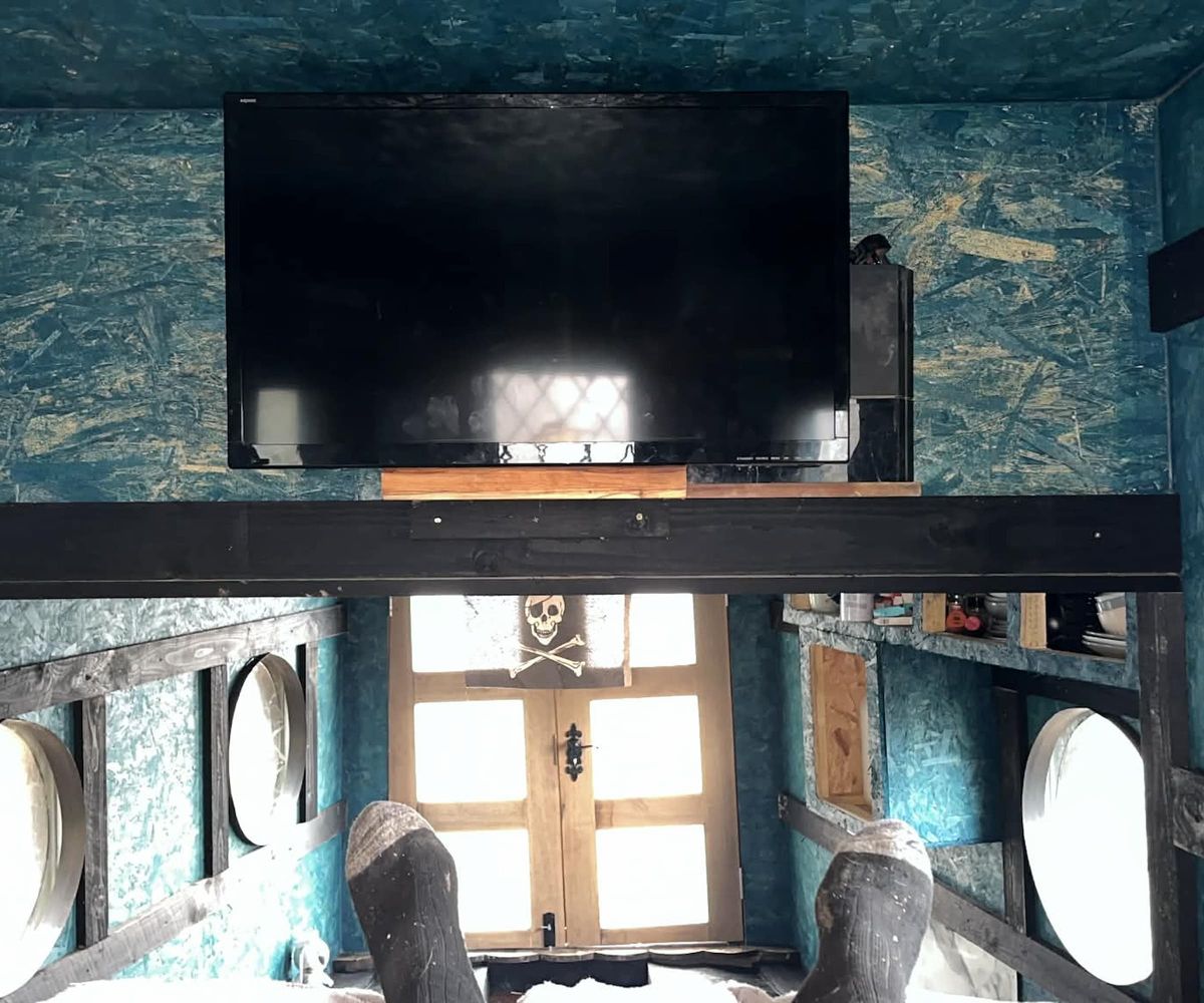 A TV on a wall in a boat house