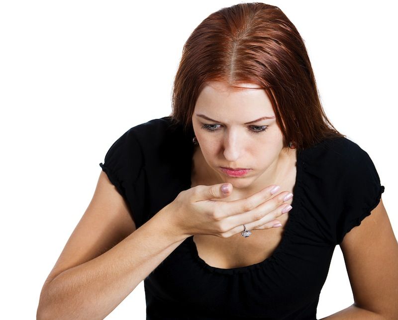 A woman looks sick after eating something.