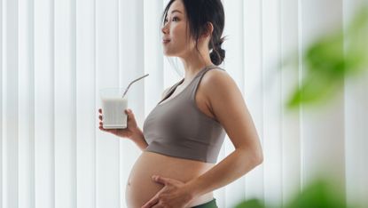 Pregnant woman drinks a probiotic drink