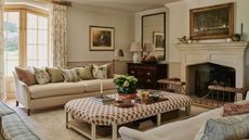 neutral living room country style with beige soft carpet, patio doors, two neutral sofas and a patterned ottoman
