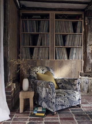 Livign room with bookcase and armchair in Morris & Co fabric