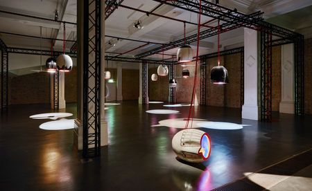 Bulbous ceramic jugs hang upside down in the darkened Whitechapel Gallery